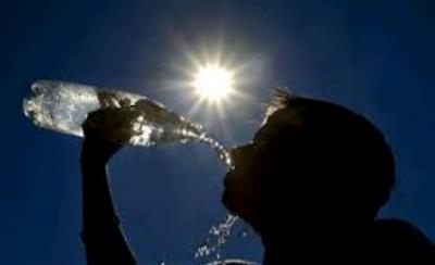 una persona beve al sole per difendersi dal calore
